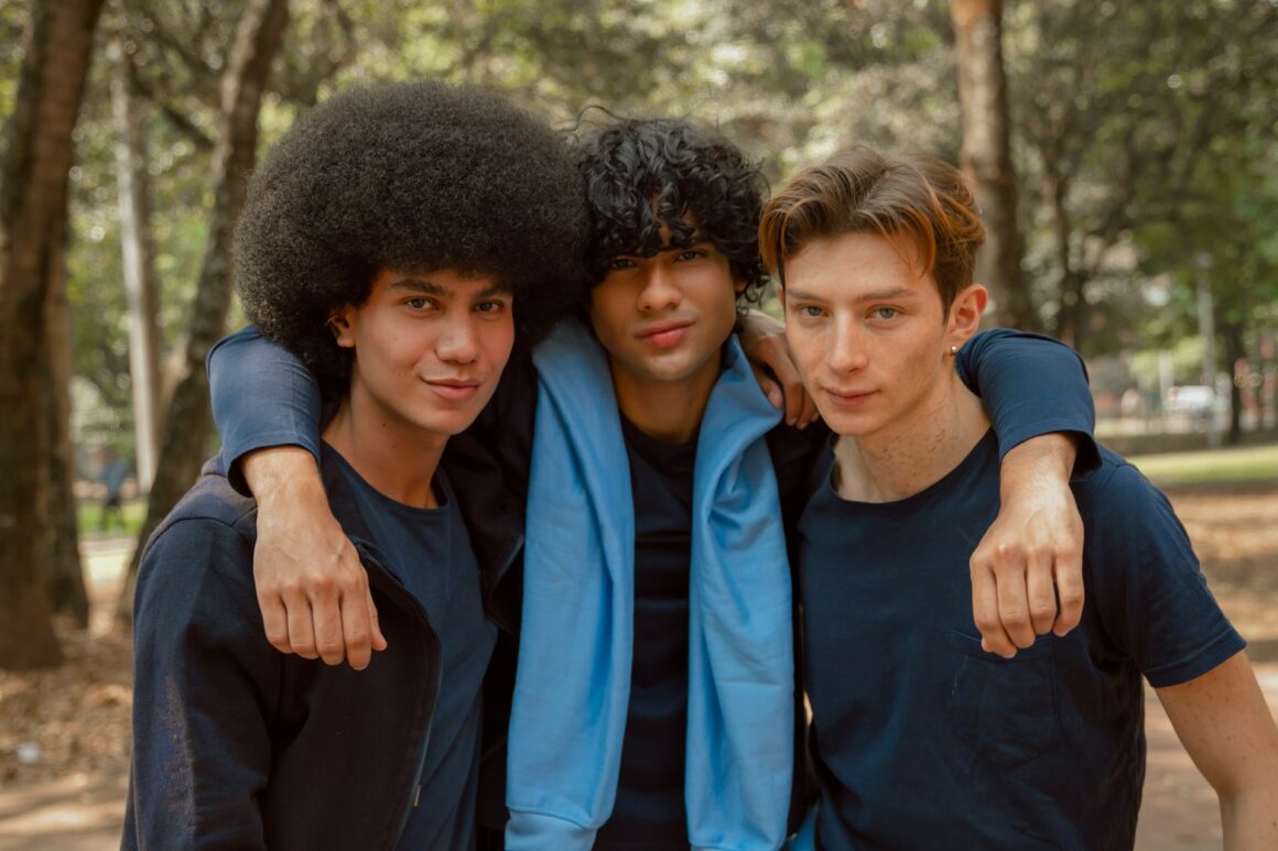 A group of male friends posing for the camera with their arms around each other