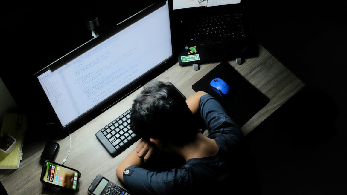 A guy who’s fallen asleep on his keyboard at his desk