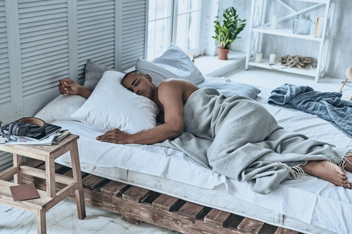 A man fallen asleep in a modern, seaside-styled bed