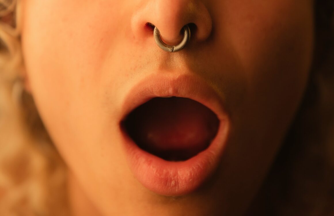 A close-up of a woman with her mouth open in a sexual manner