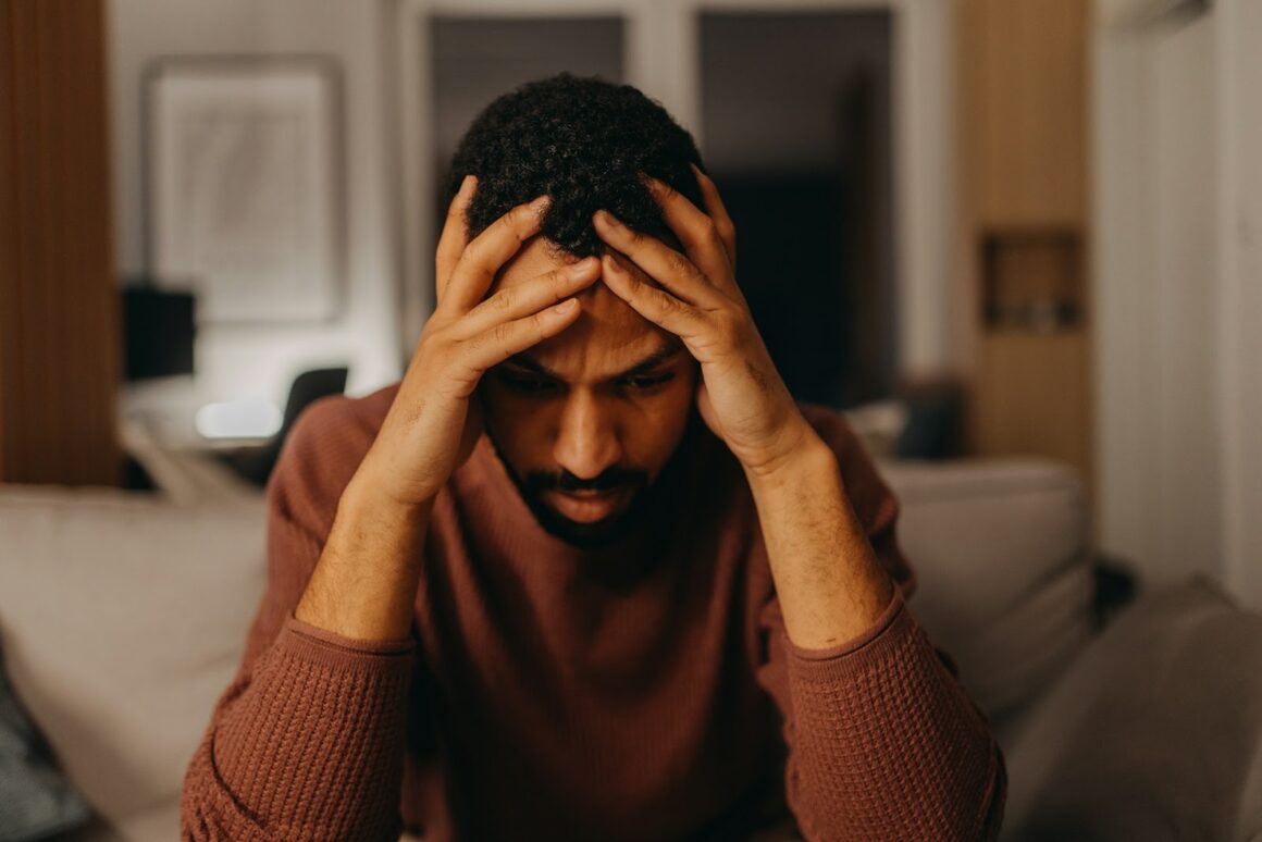 A man with his head in his hands looking sad and stressed