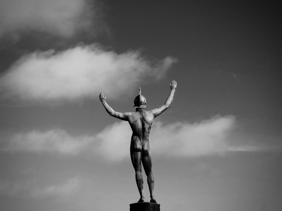 A statue of a soldier holding his arms open wide to the sky