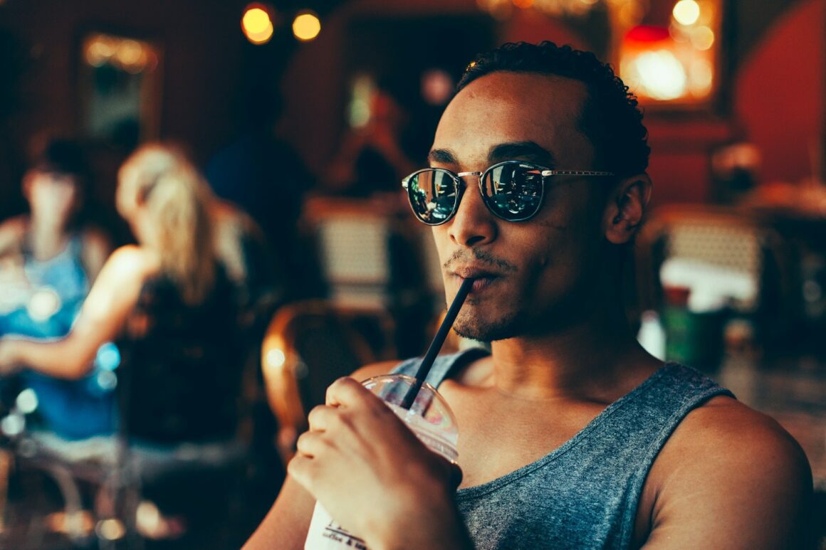 A man in sunglasses sipping a sexy drink