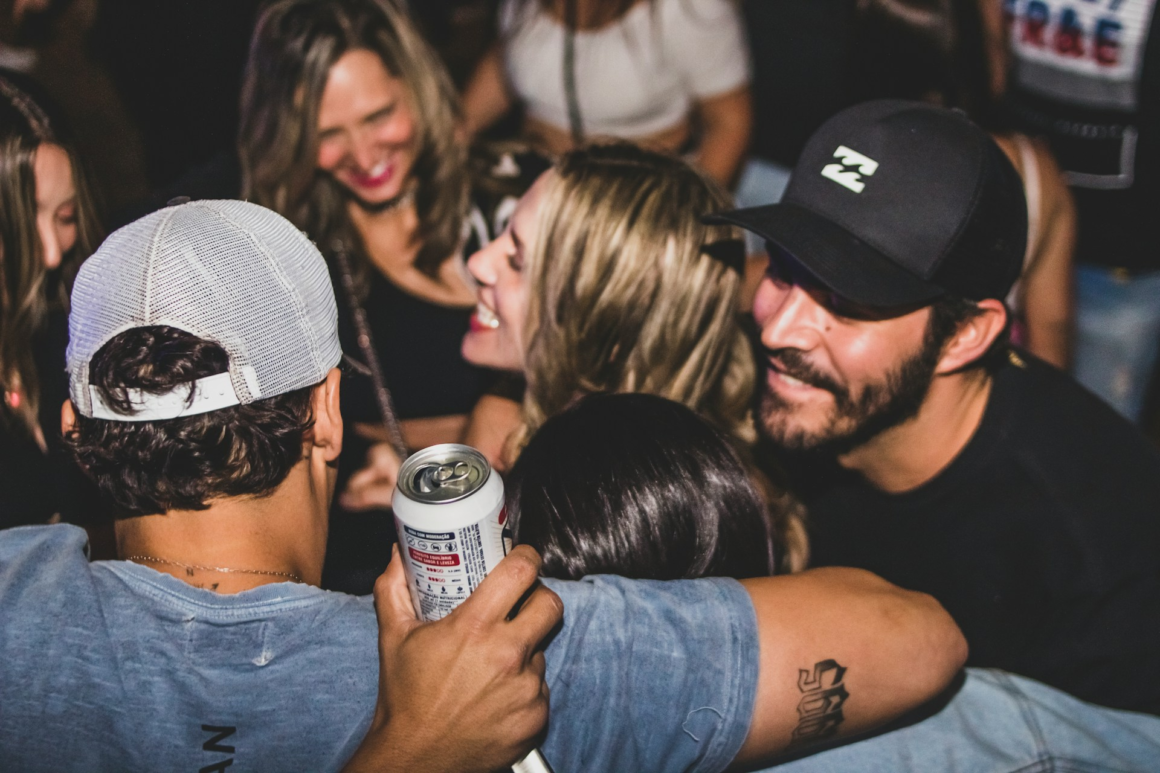 A group of guys with their arms around each other while partying