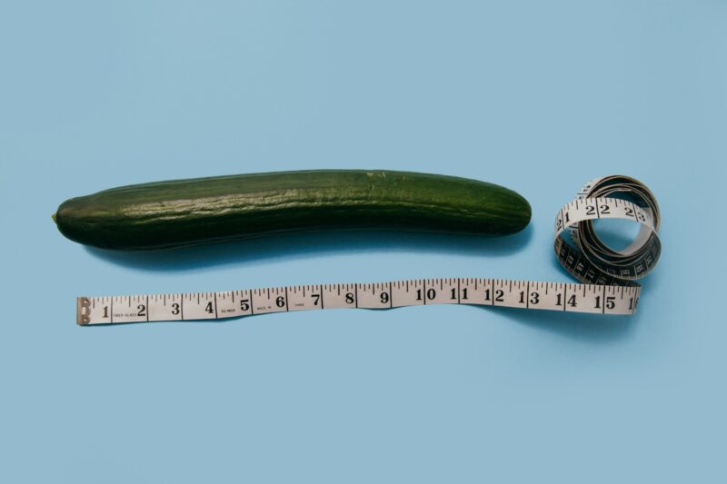 A cucumber representing the average penis size with a tape measure next to it