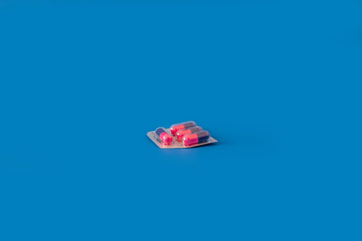 A bright blue aesthetic background with a little pack of four multi-colored pills for erectile dysfunction