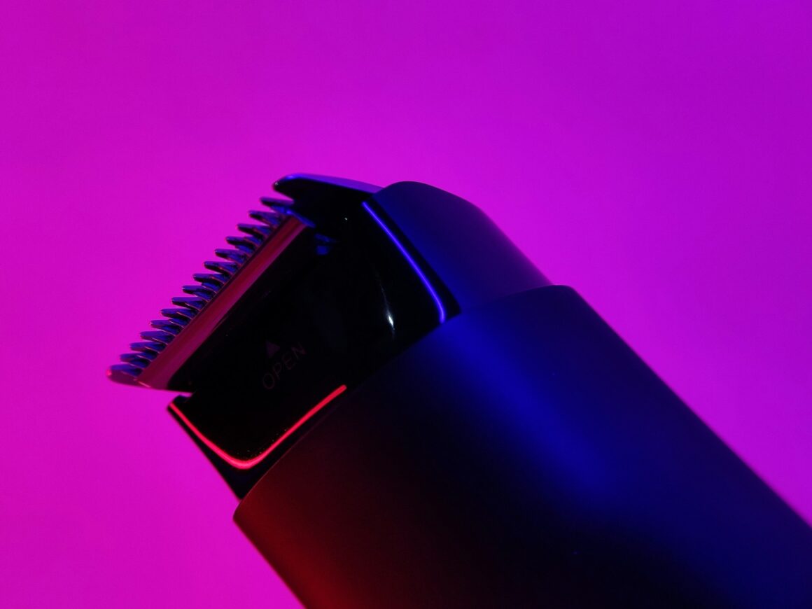 An aesthetic shot of a pubic hair trimmer on a neon purple background