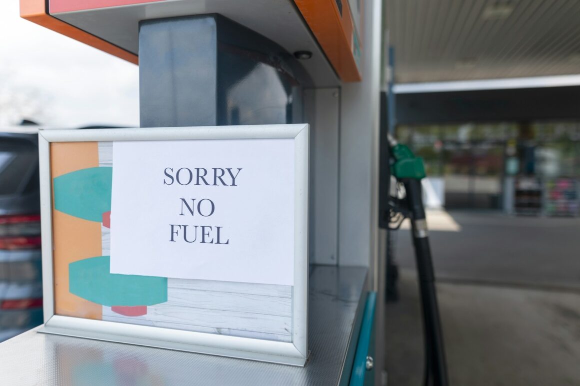 A gas station with a "sorry, no fuel" on the pump