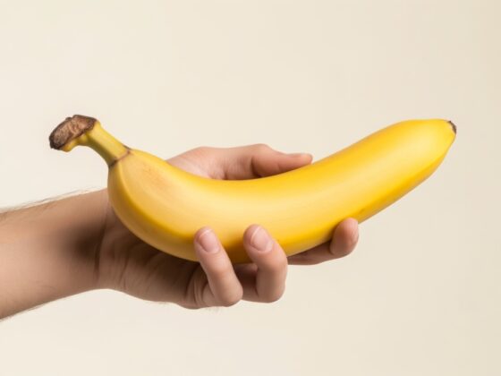 hand holding a smooth unpeeled banana