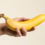 hand holding a smooth unpeeled banana