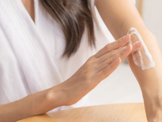 woman applying moisturizer on her arm