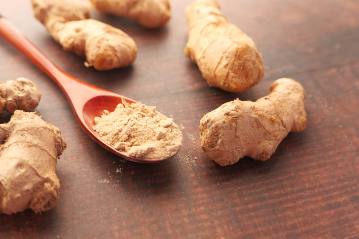 close-up of ginger and powdered ginger on a cutting board