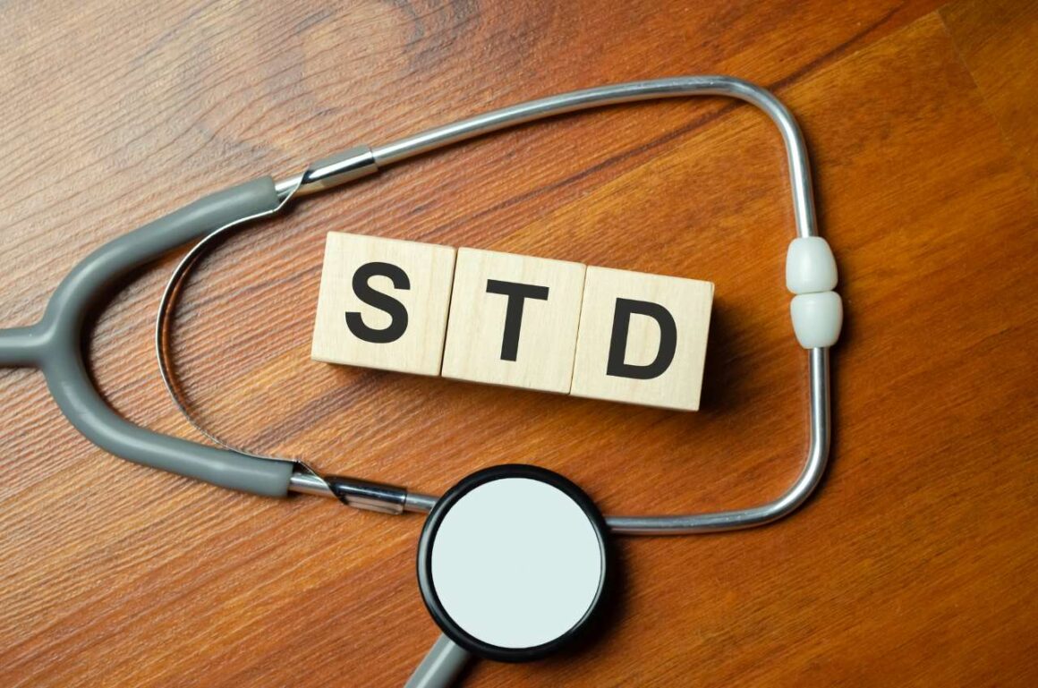 Wooden blocks with the inscription STD with stethoscope on a wooden table