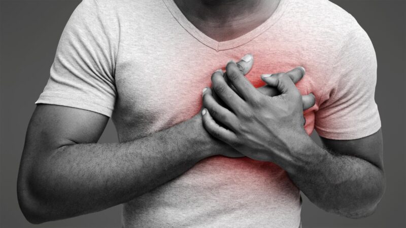man having heart ache, holding hand on chest