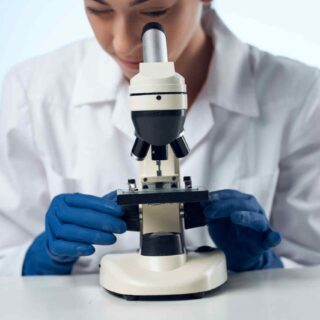 a female doctor looking through a microscope