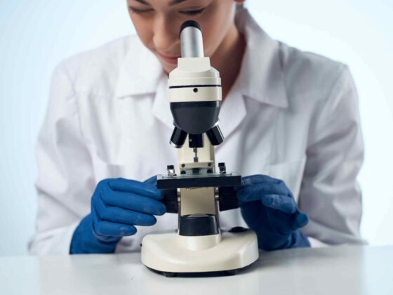 a female doctor looking through a microscope