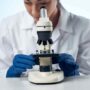 a female doctor looking through a microscope