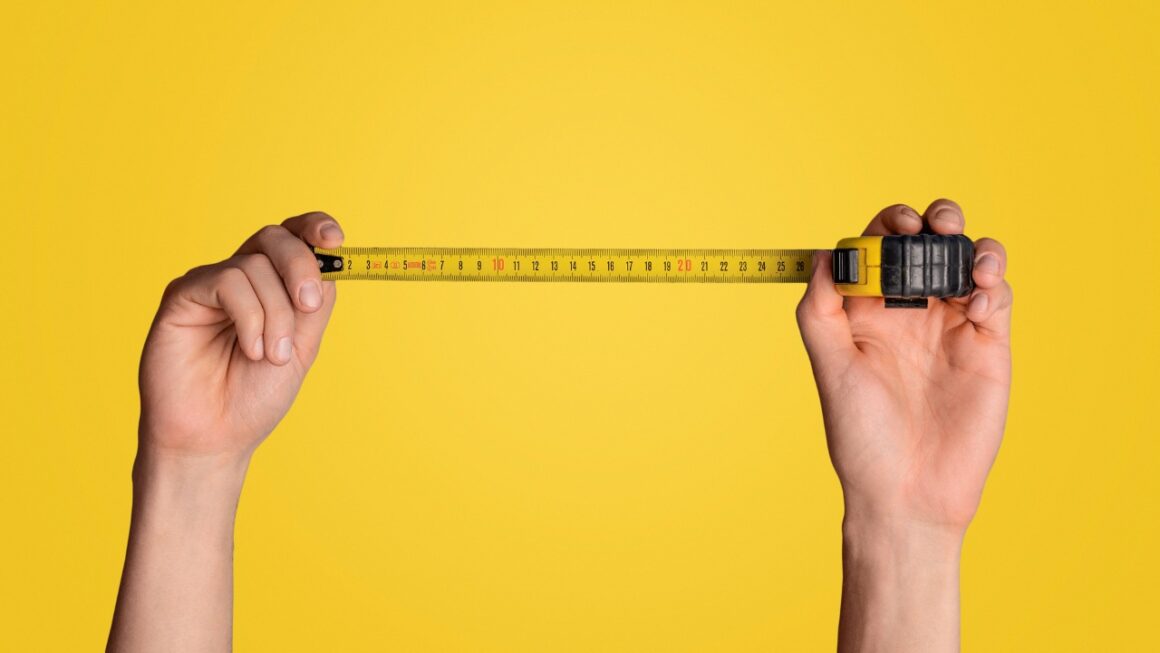 tape measure being held by two hands on a yellow background