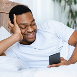 man smiling looking at his smartphone