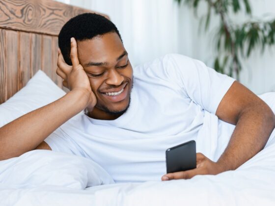 man smiling looking at his smartphone