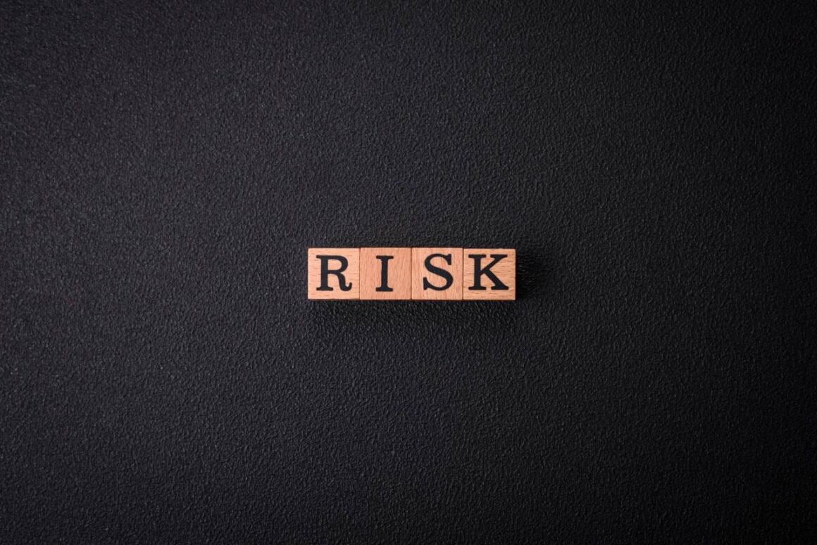 word risk spelled on wooden blocks on black background