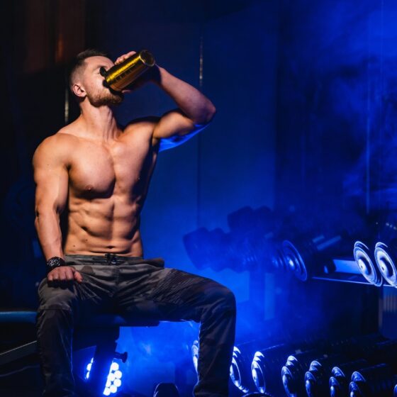 man drinking pre-workout in a gym