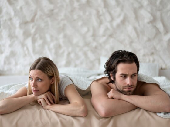 Stressed young couple lying in bed