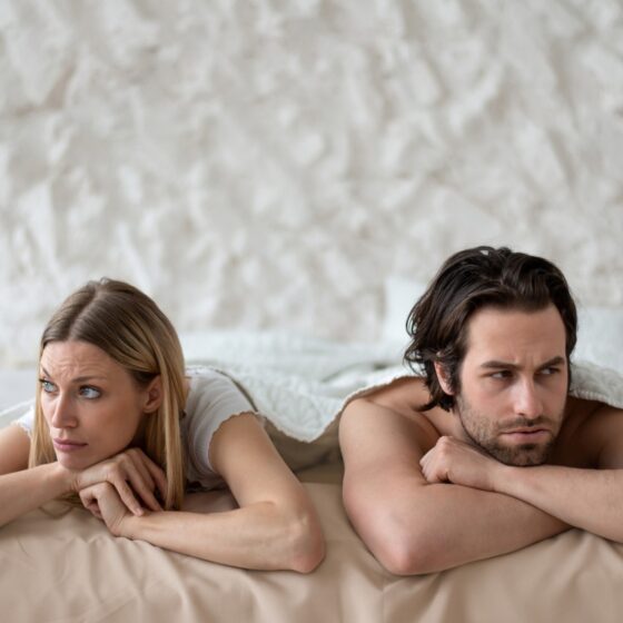 Stressed young couple lying in bed