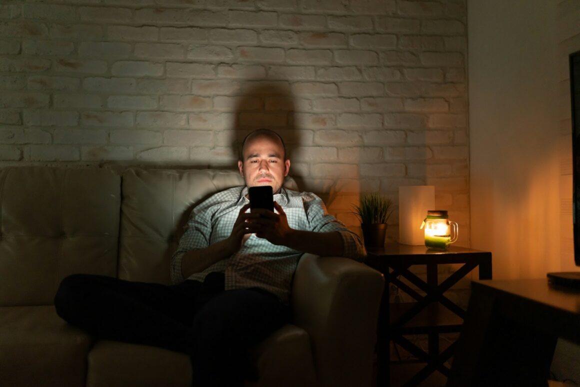 A guy using his phone to Google something at night