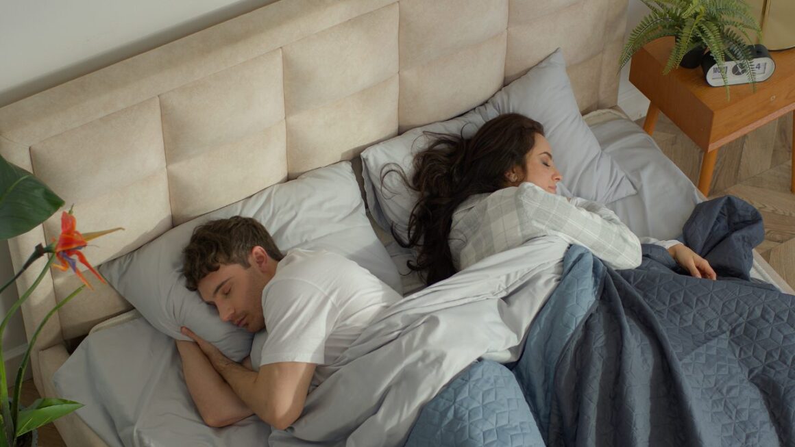 couple sleeping in bed facing opposite of each other