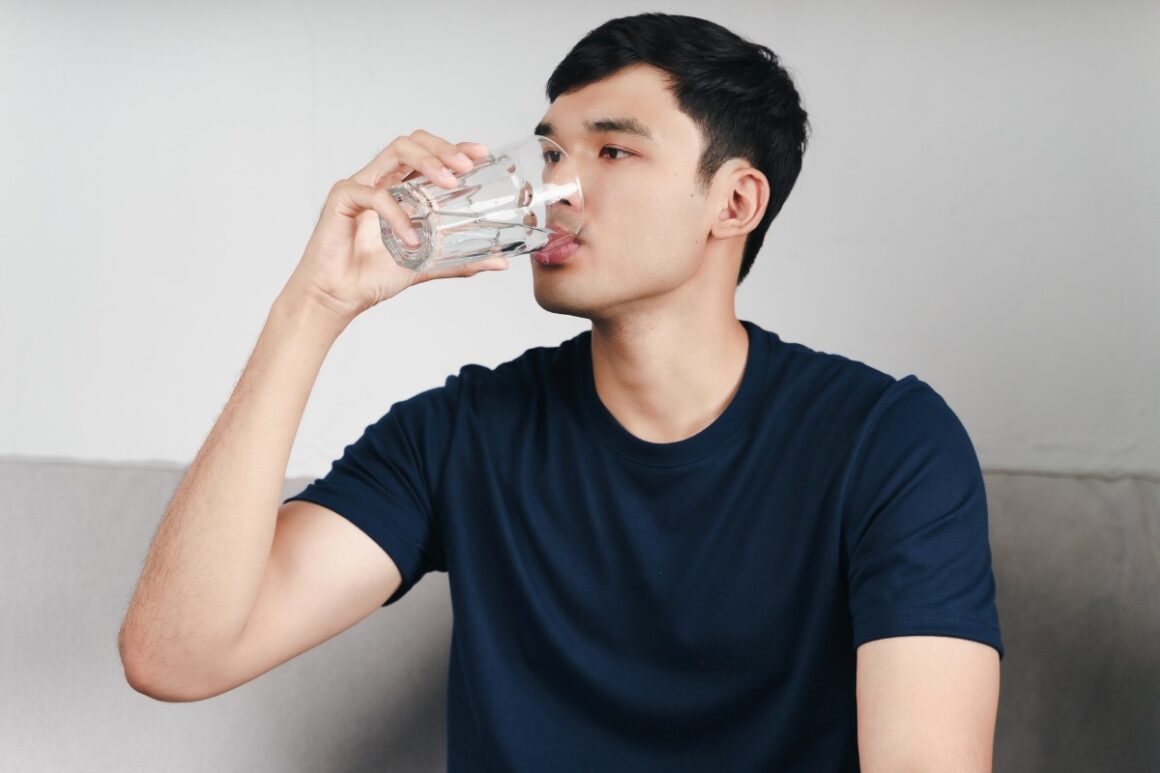 man drinking water from a glass
