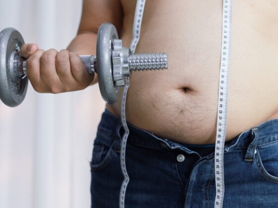 Overweight man exercising by lifting weight with a dumbbell