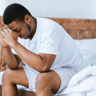 depressed man sitting on bed