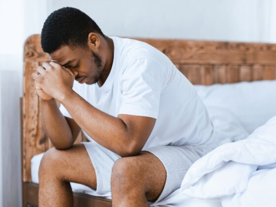 depressed man sitting on bed