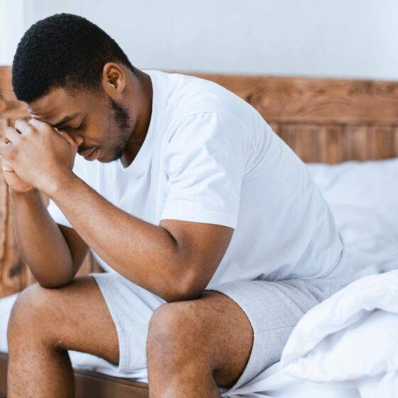 depressed man sitting on bed