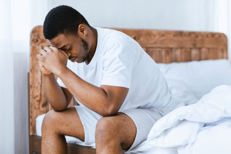 depressed man sitting on bed